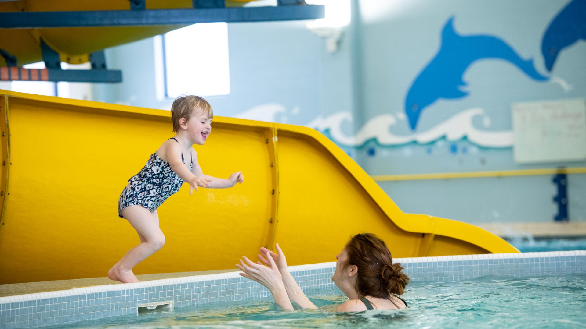 Little girl jumping into the pool 