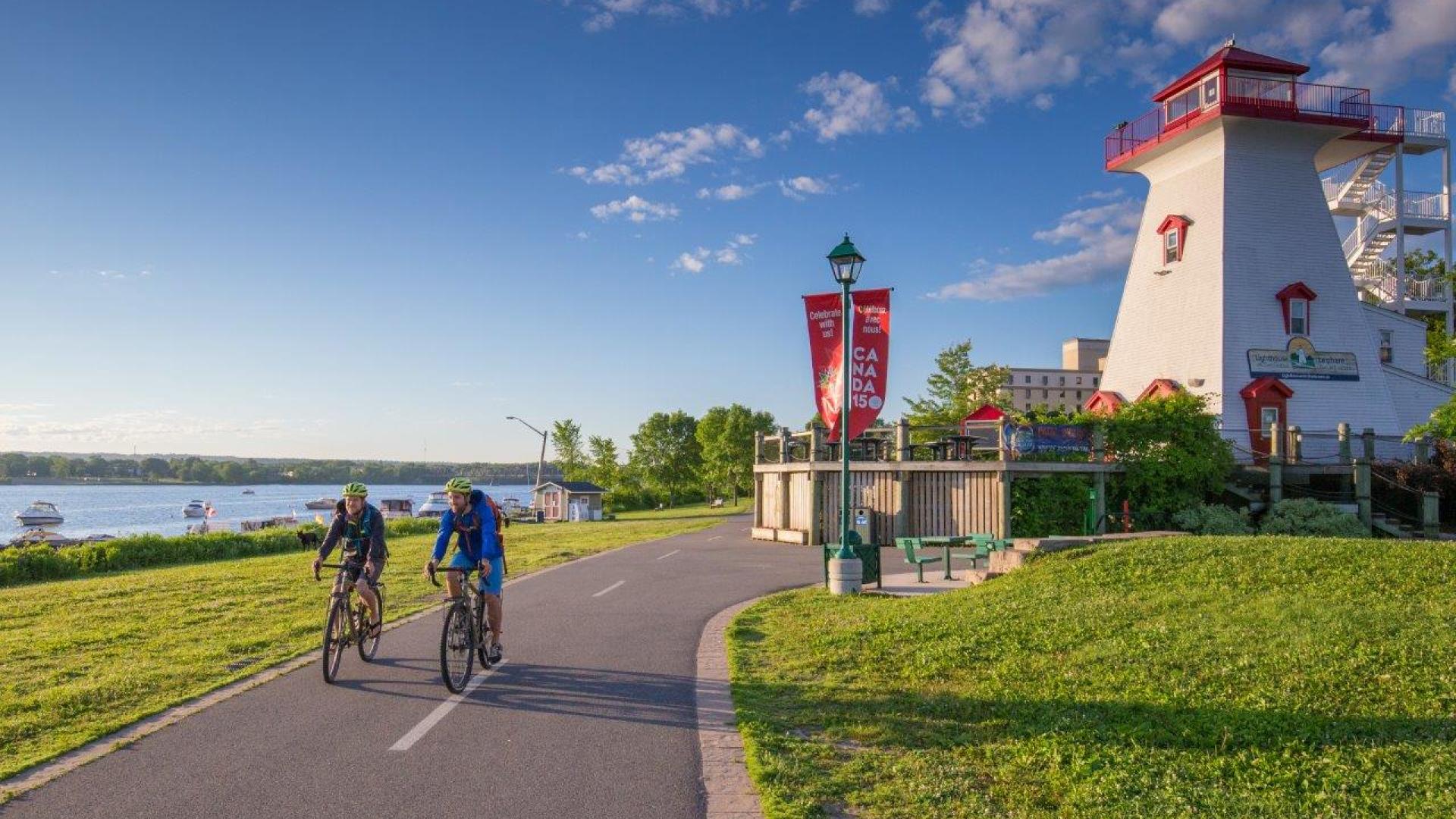 Two bikers biking by the lighthouse