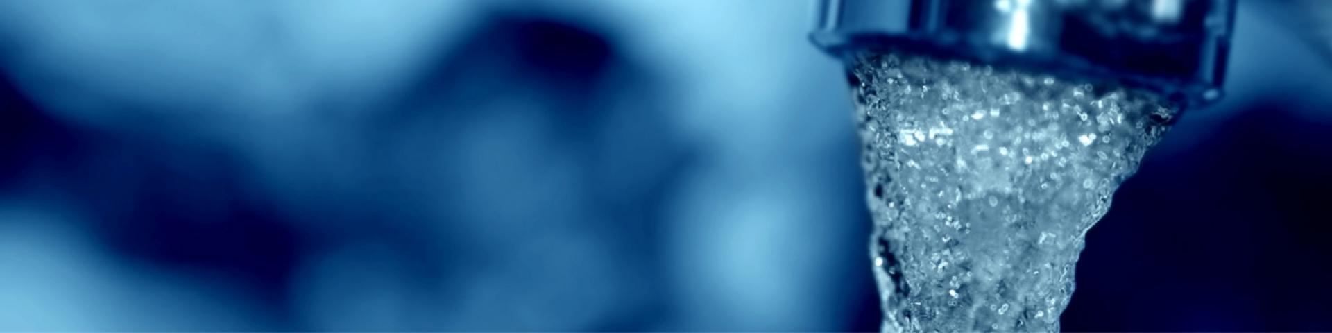 Water coming out of water faucet. There is a blue hue on the image.